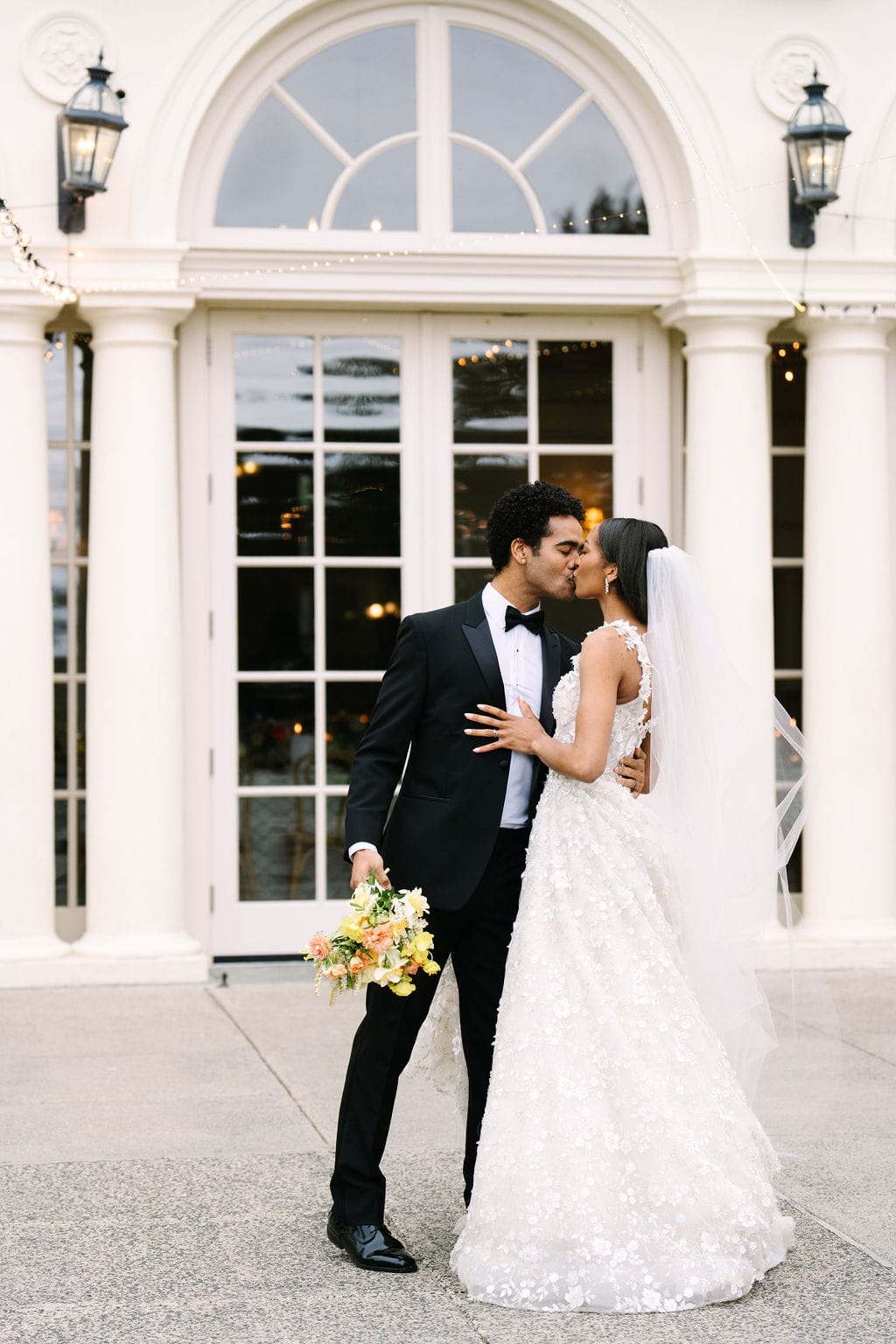 groom kissing the bride on the patio of the wadsworth mansion during their ct wedding