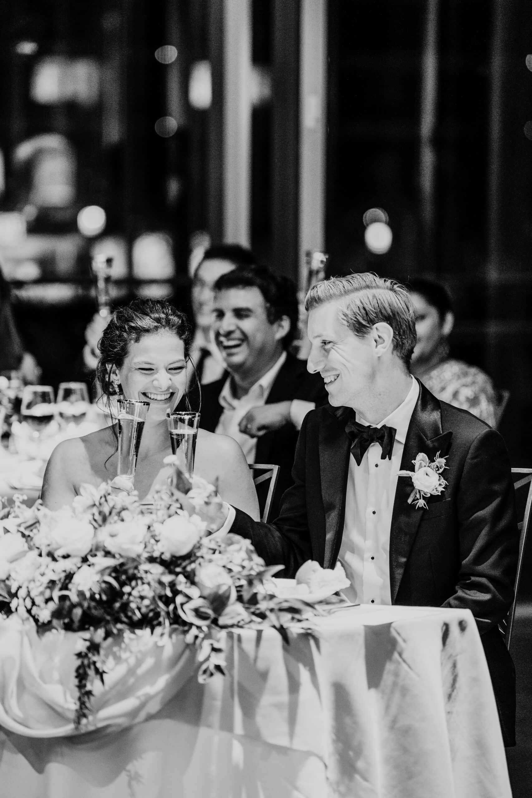 black and white photo of bride and groom raising their glasses at their ica boston wedding