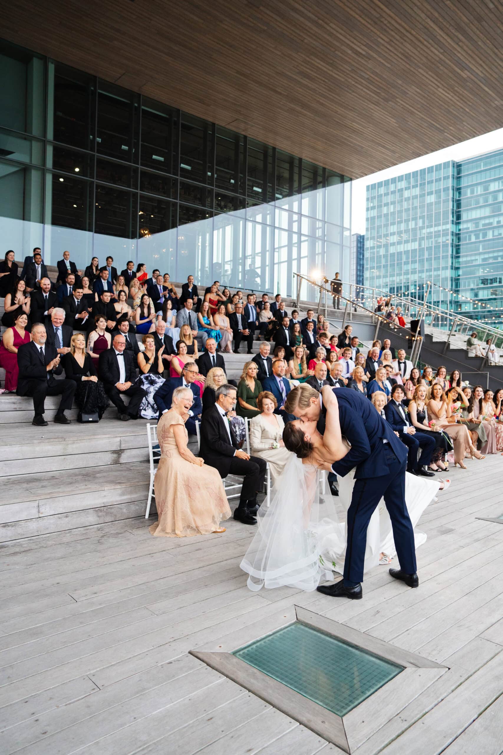 bride and groom dip first kiss from behind at their institute of contemporary art wedding in boston massachusetts