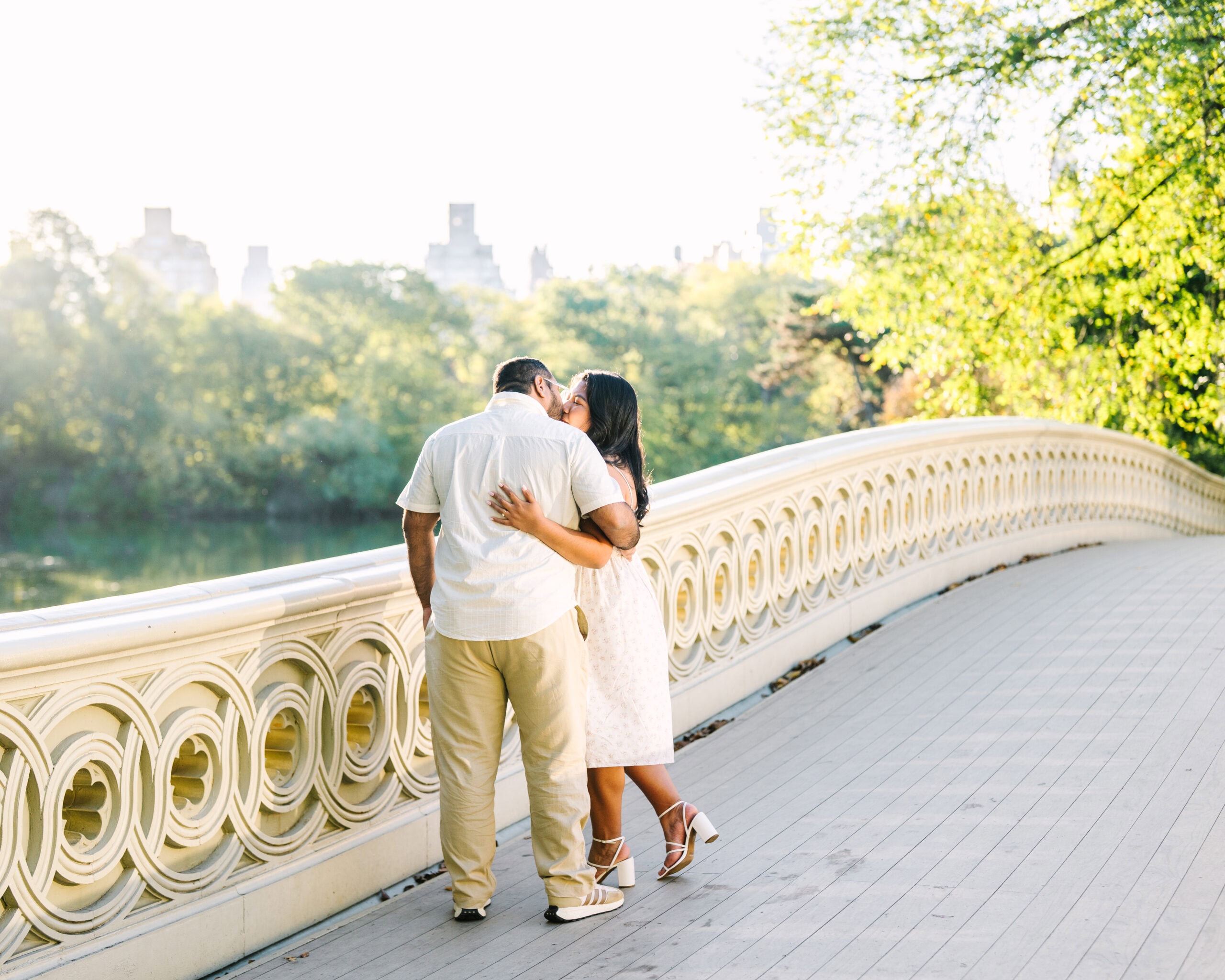 couple kissing on bow bridge in central park captured by nyc engagement photographer meghan lynch