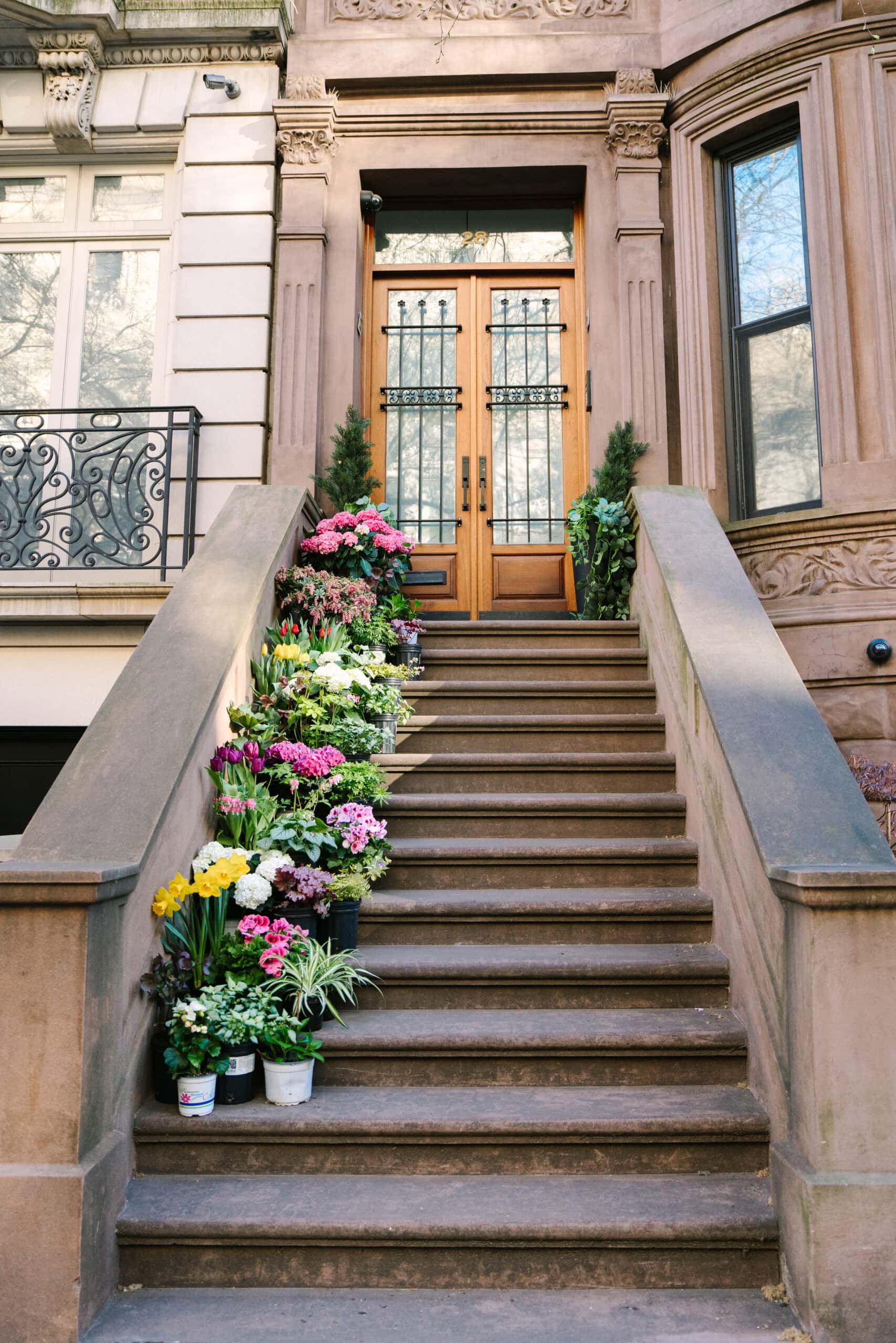 a line of flower pots on the stairs of an upper west side nyc brownstone apartment