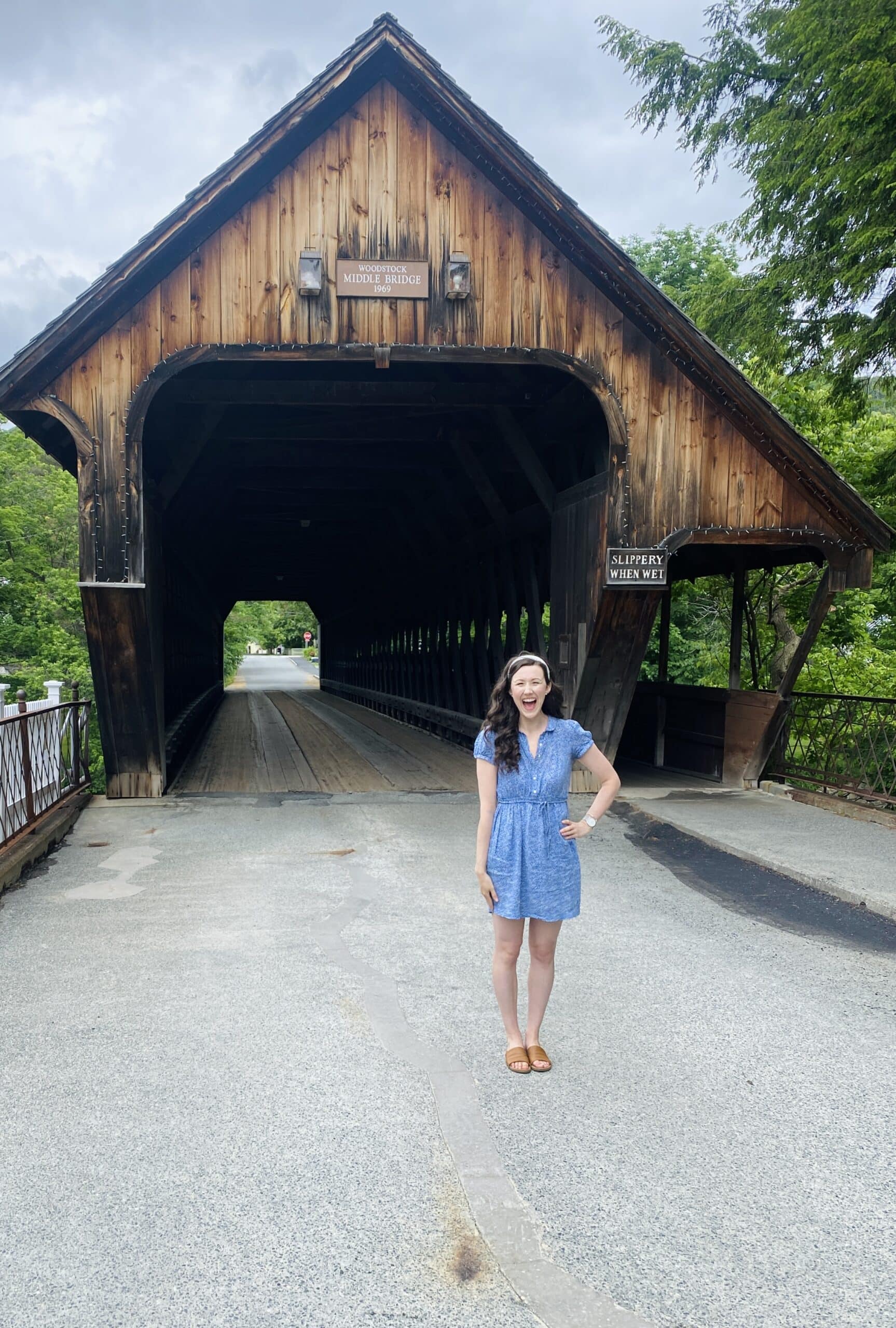 new england travel blogger meghan lynch smiling in front of the woodstock covered bridge